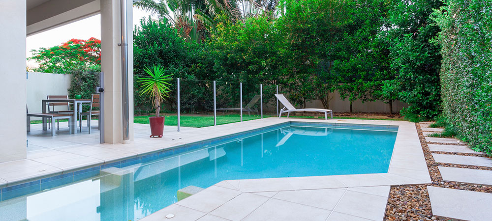 Backyard pool with glass fence